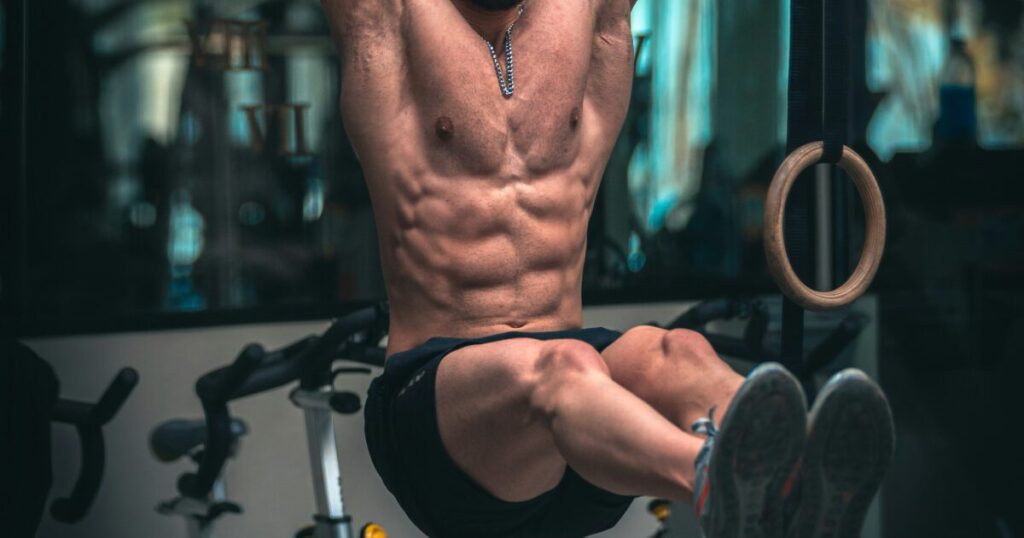 吊り輪トレーニングで腹筋を鍛える男性