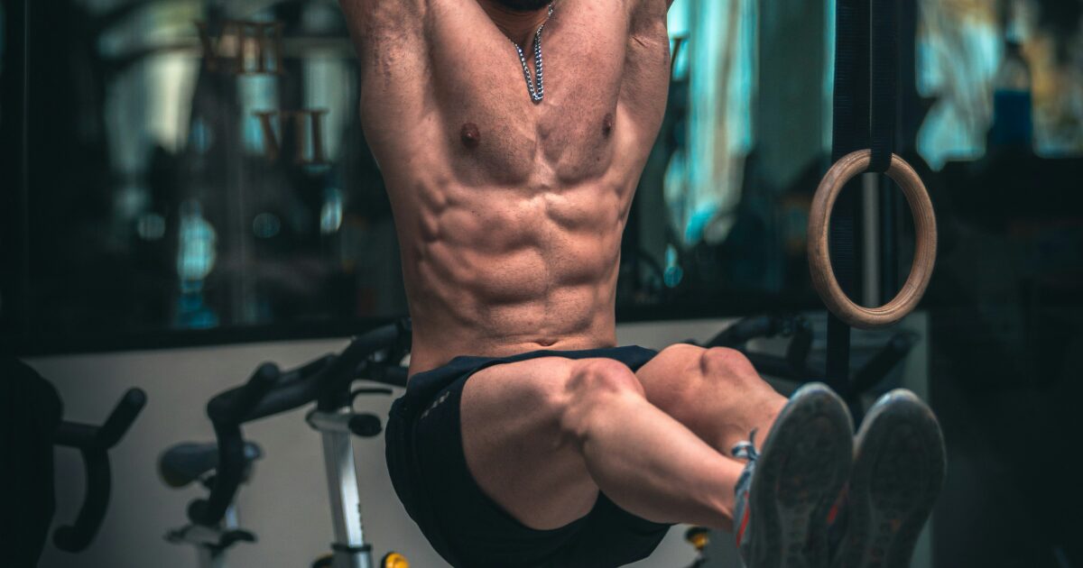 吊り輪トレーニングで腹筋を鍛える男性